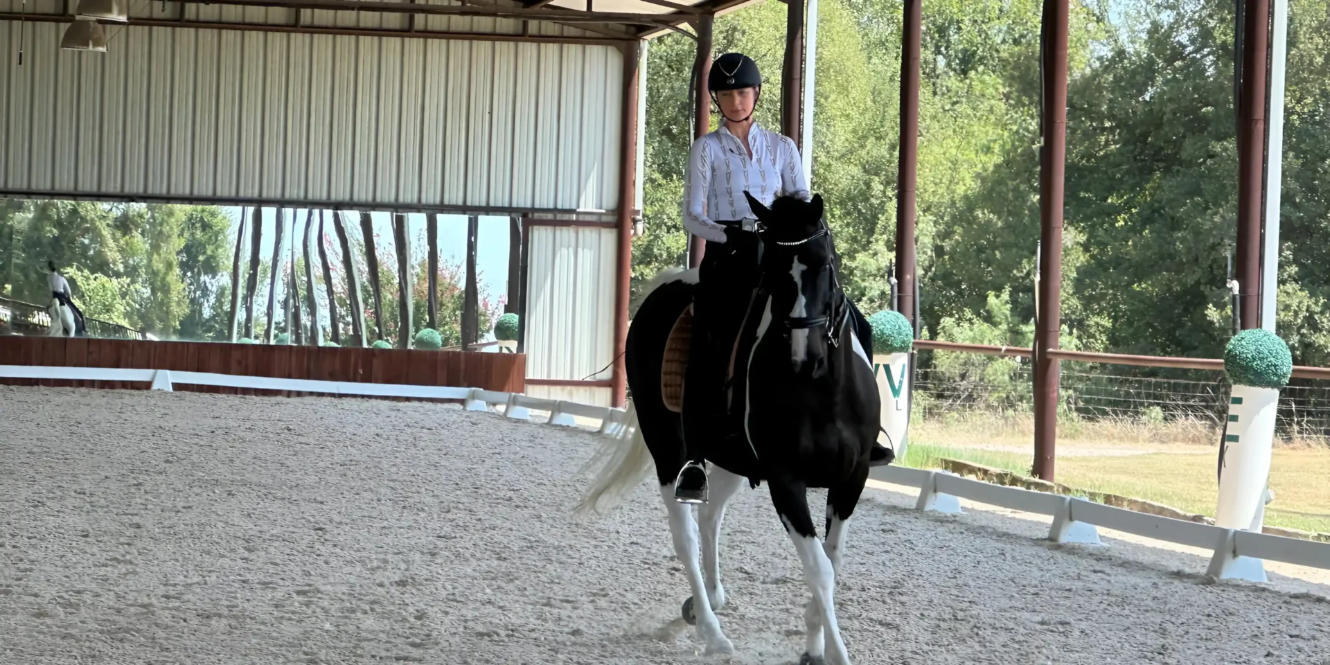 Woman riding black and white horse.